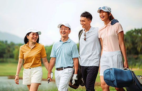 Happy multi-generational Asian family playing games on a grassy field during a camping trip